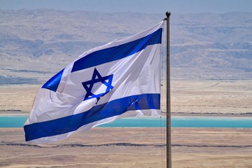 View of Dead Sea and Jordan in the Judean Desert, with Israeli flag in foreground, seen from Masada