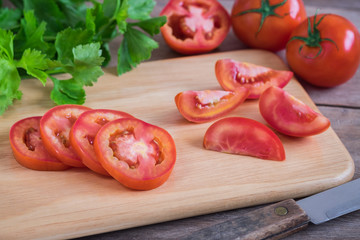 Tomato sliced on wooden cutting board