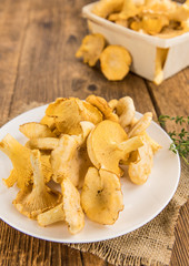 Fresh harvested Chanterelles (on a wooden table)