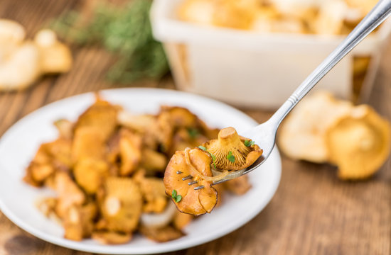 Fried Chanterelles on wooden background; selective focus