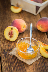 Peach Jam on wooden background; selective focus