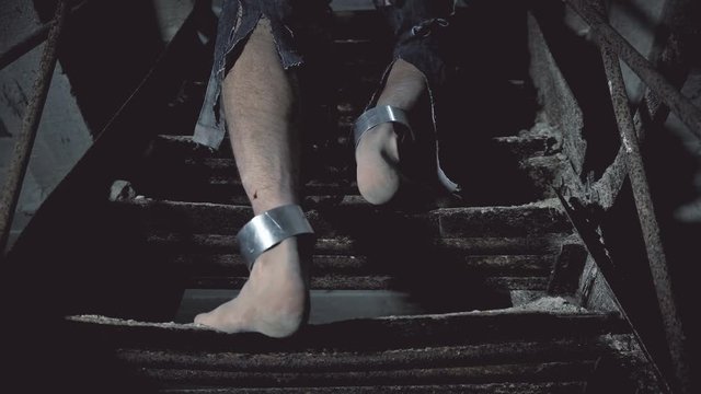 prisoner in chains coming up the stairs