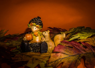 Young boy with pumpkin and squirrel on an orange background.