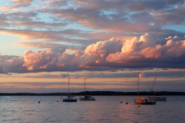 Sunset over the lake Mendota.  Amazing colors sky with clouds colored by setting sun over yachts on a lake. Memorial Union Terrace shore, city of Madison, the capital of Wisconsin, Midwest USA.