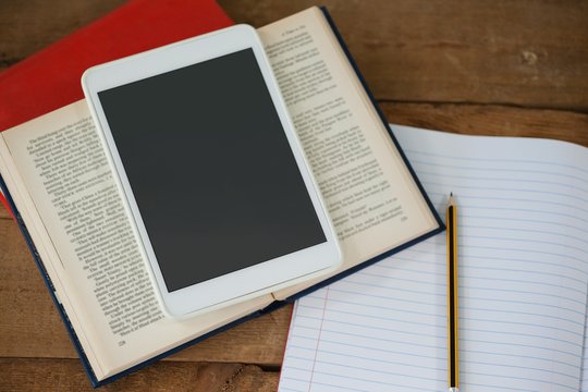 Digital Tablet And Books On Table In Classroom