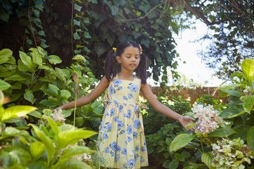 Girl standing amidst green plants