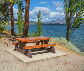 Picnic area with table and benches on a shore of Okanagan lake