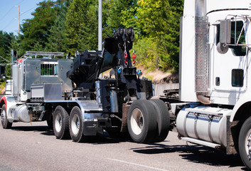 Big rig towing semi truck tow ather semi truck tractor on the road