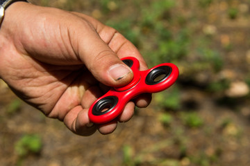 Man playing with fidget spinner stress relieving toy outdoor
