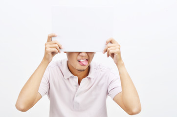 Asian man tongue out holding white paper card covering eyes