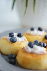 traditional morning homemade breakfast cottage cheesecakes with sour cream and berries.