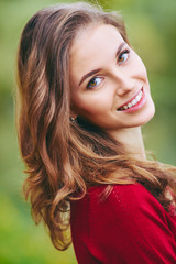 Naklejka premium Beautiful face of young woman. Outdoor portrait in autumn park