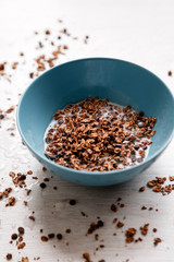 Healthy cereal breakfast. Sweet granola with milk in teal bowl on wooden background. Wholegrain vegetarian morning tasty food.