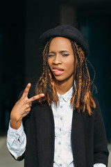 Victory gesture. Seductive young black lady. African American woman in selective focus, stylish model posing on dark background, happiness concept