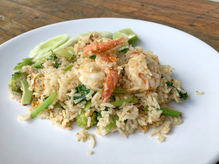 Delicious Shrimp fried rice in white dish on wooden table. Thai food.