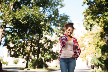 African woman walking outdoors in park.