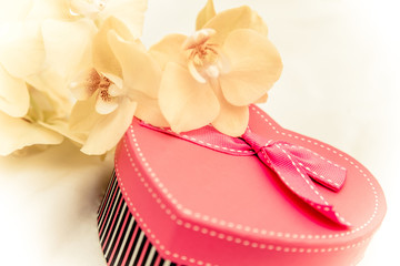 gift box in form of heart on the background of the yellow orchid 