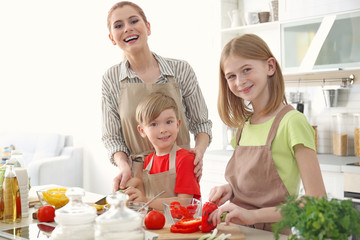 Mother and children making meal together in kitchen. Cooking classes concept
