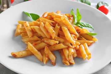 Delicious pasta with tomato sauce on plate, closeup