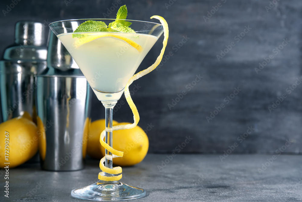 Wall mural Glass of lemon drop martini with zest on table