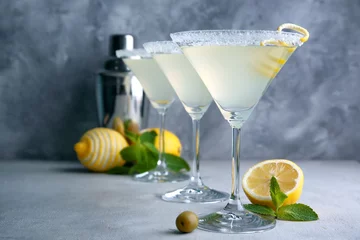 Fototapeten Glasses of lemon drop martini with zest on table © Africa Studio