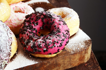 assorted donuts with chocolate frosted, pink glazed and sprinkles donuts.
