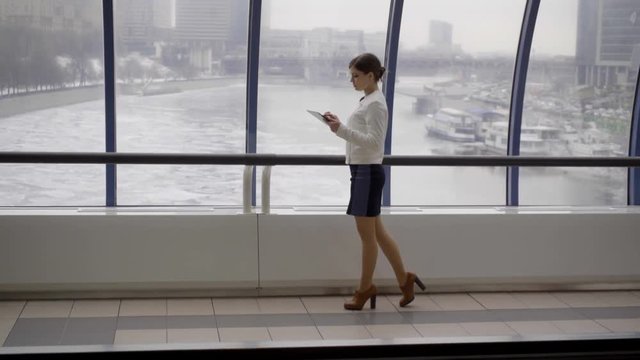  young businesswoman stay opposite window in modern business centre with tablet in hand
