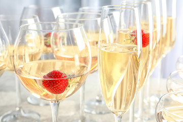 Glasses of delicious wine with strawberry on table