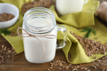 Jar with hemp milk on wooden table