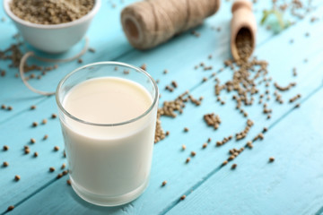 Glass with hemp milk on wooden table