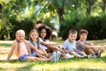 Group of children sitting on grass in park
