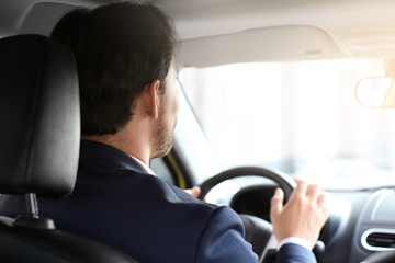 Handsome male driver in car