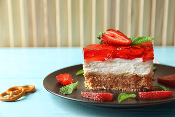 Plate with delicious strawberry pretzel salad on table
