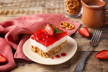 Plate with delicious strawberry pretzel salad on table