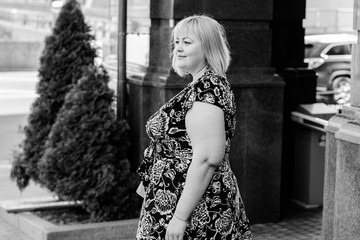 Portrait plus size young blond hair woman walk on city center in European streets 