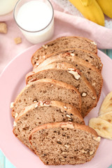 Sliced banana bread with nuts on plate, closeup