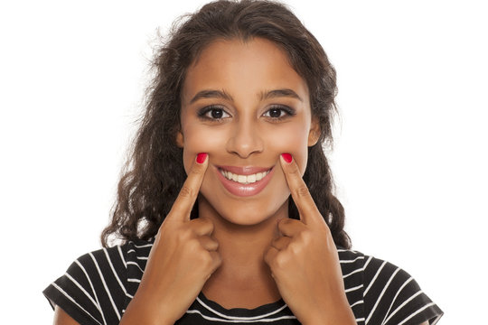 beautiful young dark skinned woman forsed her smile with her fingers