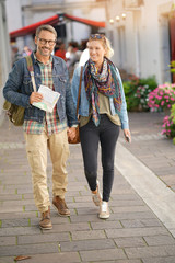 Couple of tourists walking in city street of Saint-Jean-de-luz, France