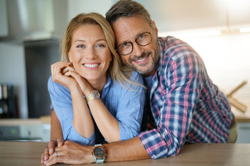 Portrait of mature couple standing in home kitchen