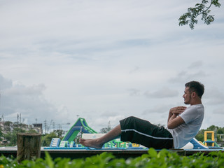 The acting setup of Yoga concept. A asian young man doing Yoga outdoor by the lake.