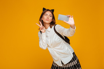 Cheerful teenage schoolgirl in uniform with backpack