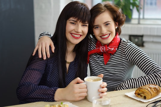 beste freundinnen umarmen sich in einem caf&eacute;