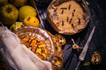 Ingredients tinctures Fruits twigs quince sugar cloves vanilla wooden table