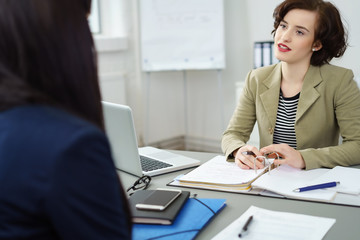 frauen unterhalten sich im büro am schreibtisch