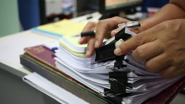 Officer Businessman searching data in Stacks of papers files on work desk in office, business report paper or piles of unfinished documents notation with clips on offices desk, Business concept