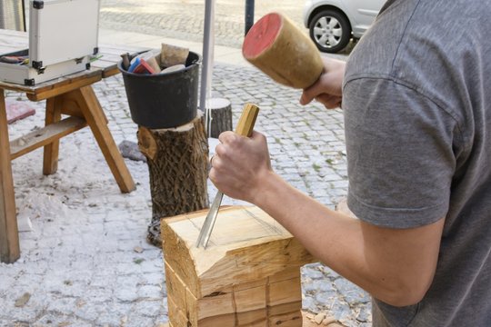 Holz wird mit Holzhammer und Stechbeitel bearbeitet 