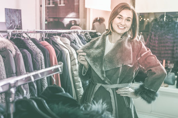 Girl choosing sheepskin coat