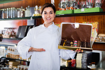 Female seller offering large box of chocolates