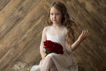 Girl, model with a bouquet of flowers in a beautiful interior studio. Childhood, beauty, portrait.