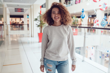 Curly haired girl with freckles in blank grey sweatshirt. Mock up.